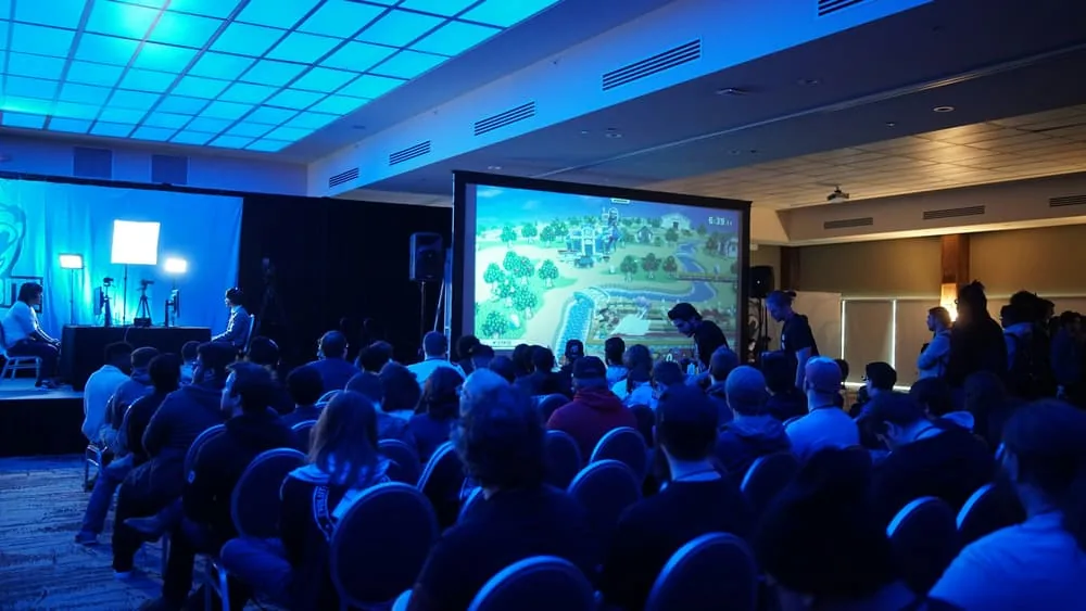 Conference audience facing a lit general-session stage