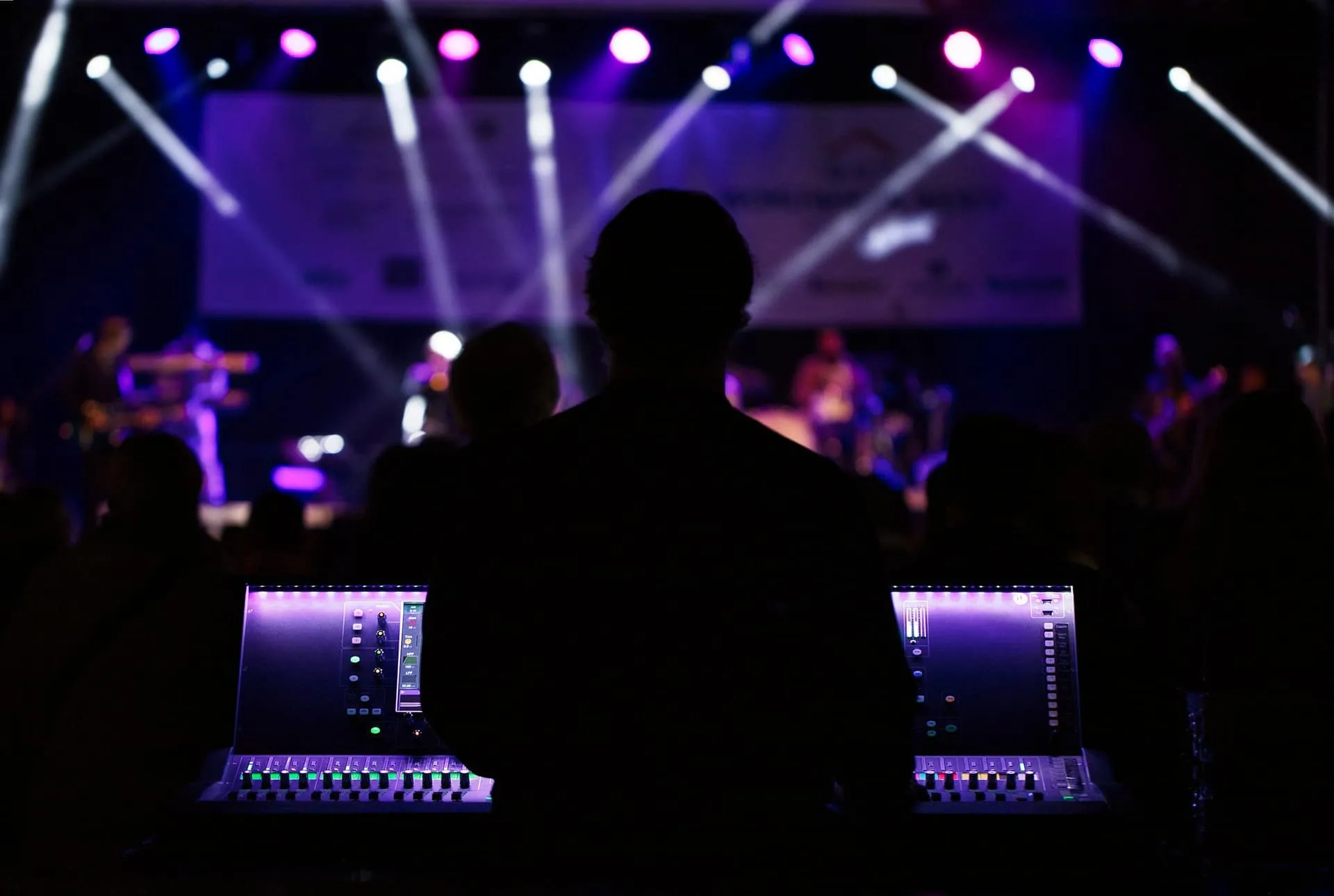 Audio engineer mixing a live event at a front-of-house console