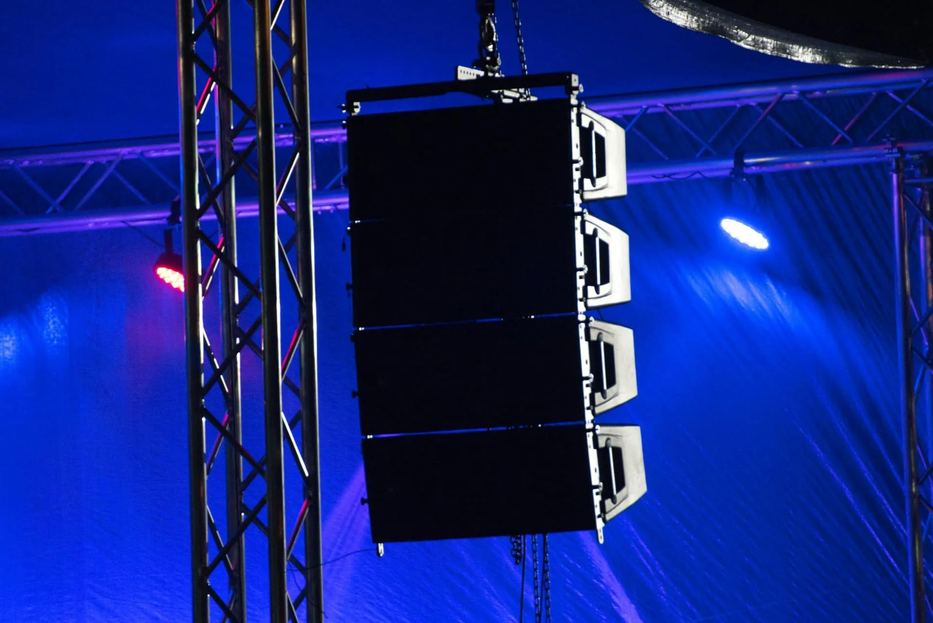 Line array speakers flown beside a concert stage